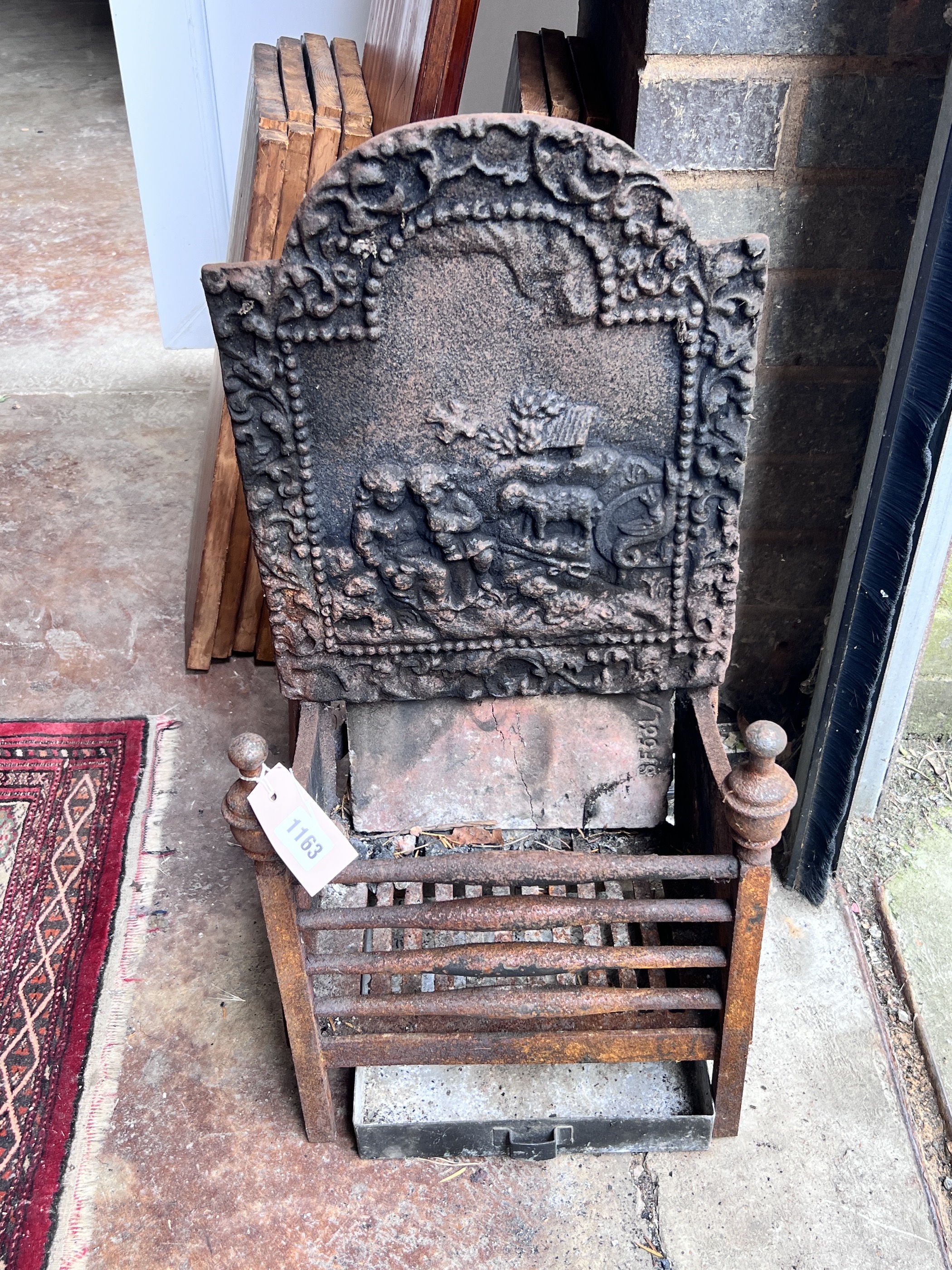 A small cast iron fire grate, width 33cm, depth 23cm, height 66cm